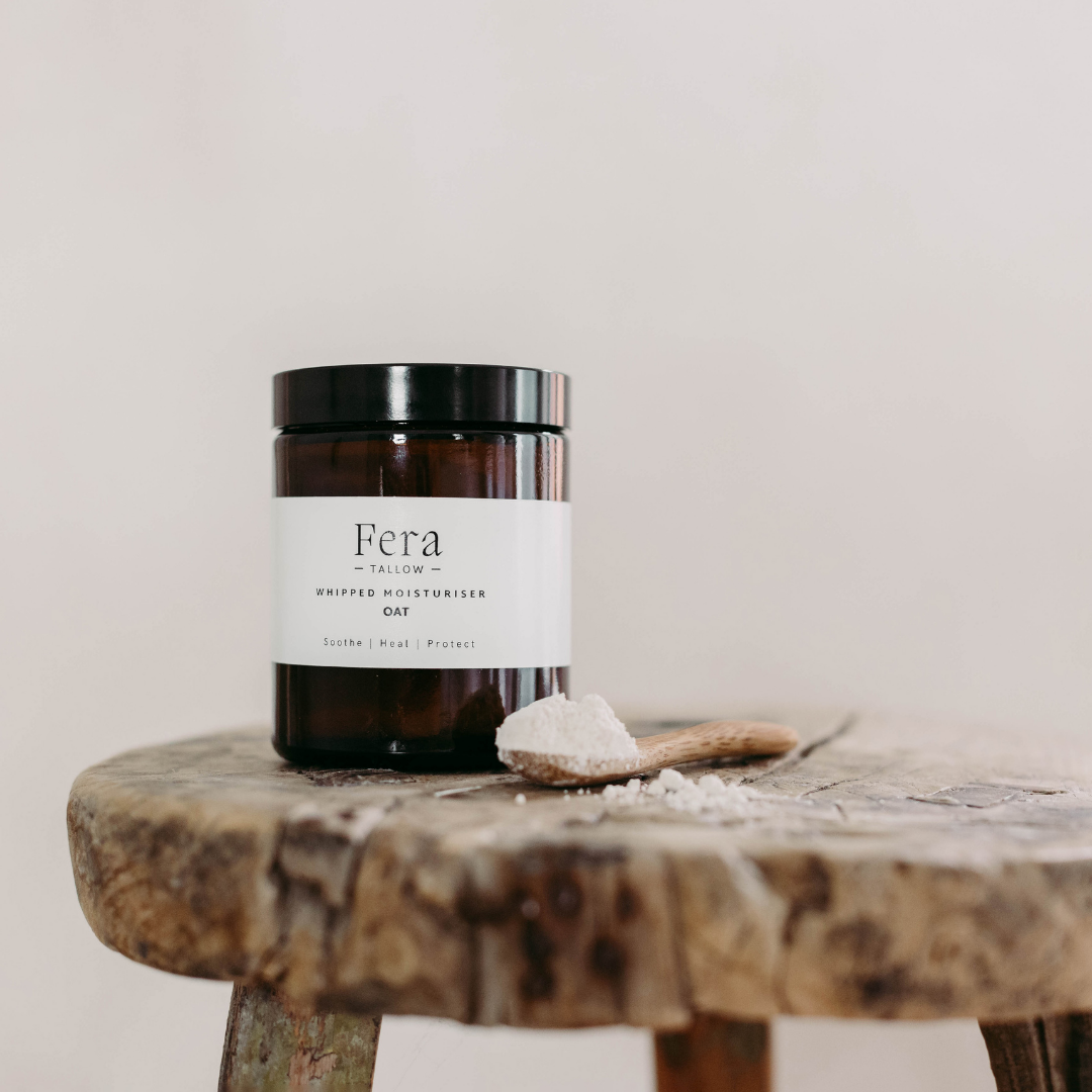 Fera Tallow whipped oat tallow moisturiser jar on a wooden surface with a neutral background