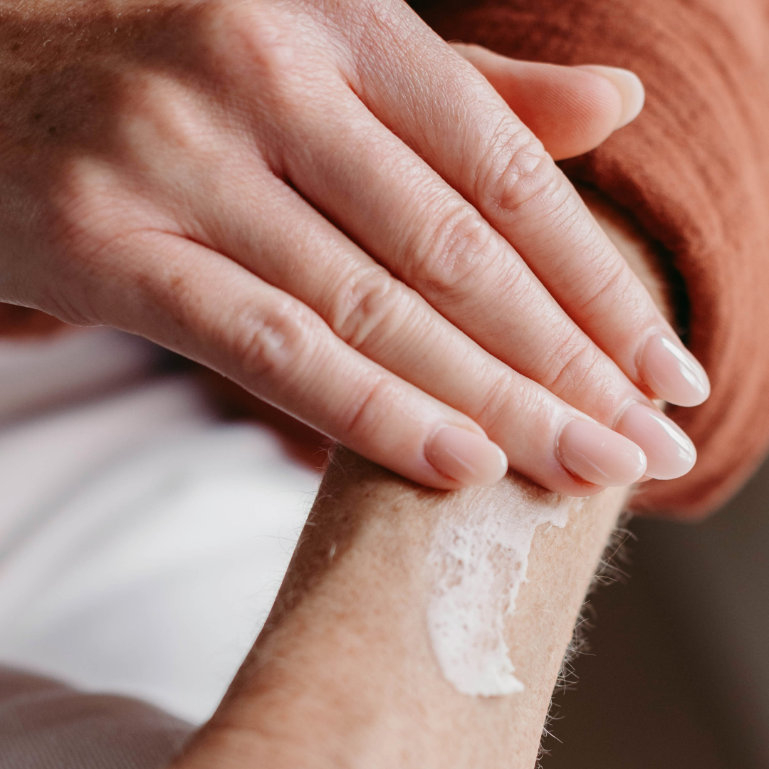 Close up of hand applying beef tallow to a person's arm