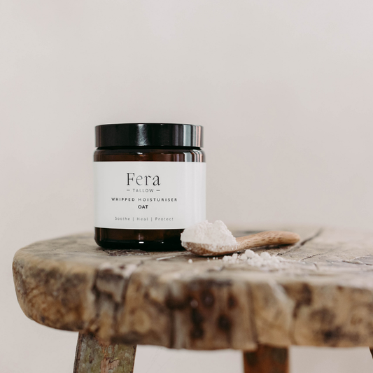 Fera Tallow whipped oat tallow jar on a wooden surface with a white background